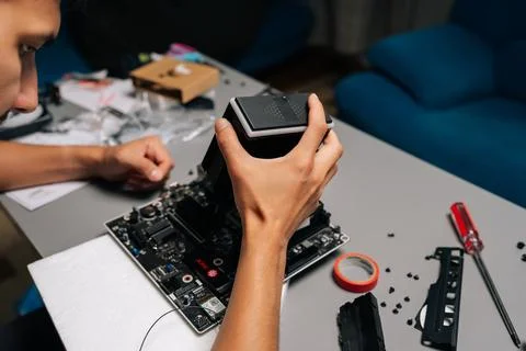 Close-up of computer technician installing CPU cooler on motherboard, working in Stock Photos