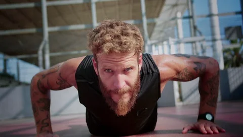 Close up of concentrated bearded man doing push-ups with tattooed hands at sport Stock Footage 116740346