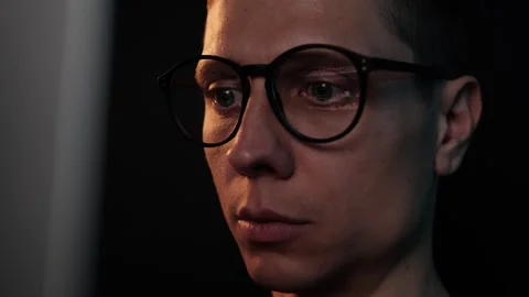 Close-up of concentrated crypto analyst in eyeglasses looking at monitor with Stock Footage 306126537