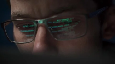 Close up of concentrated programmer in glasses works late at night Stock Footage 314259556