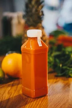 Close up concept of plastic bottle with orange carrot juice on the wooden table Stock Photos