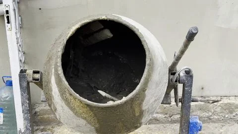 Close up of concrete being mixed inside a cement mixer. The rotating drum ble Stock Photos