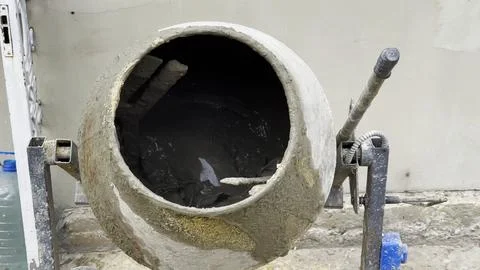Close up of concrete being mixed inside a cement mixer. The rotating drum ble Stock Photos
