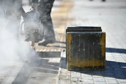 Close-up of concrete block, worker cutting with circular saw. Stock Photos