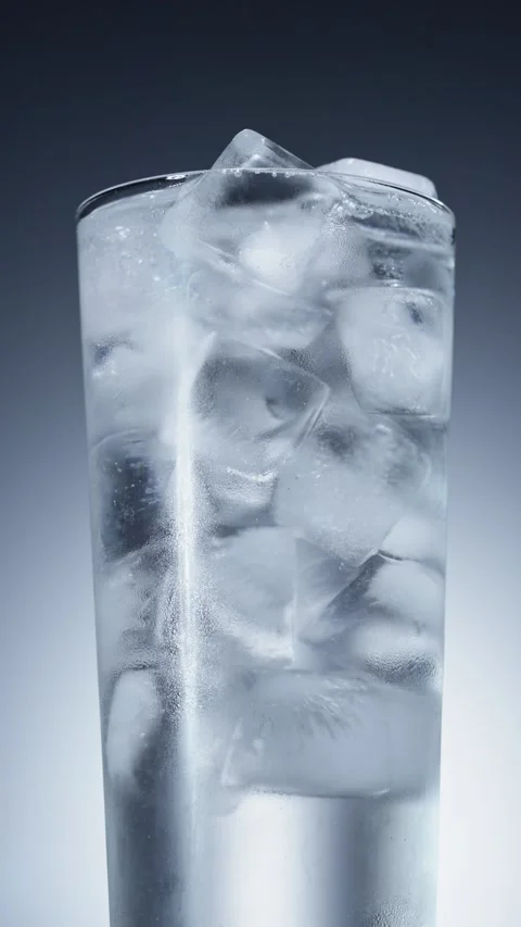 Close-up of condensed water droplets on the wall of a glass full of ice water Stock Footage 342728957