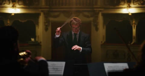 Close up of conductor directing symphony orchestra on classic theatre stage Stock Footage 154006932