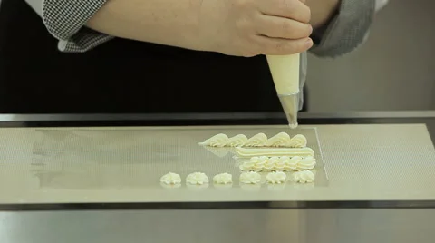 Close up of the confectioner-cook hands squeezes cream and makes parts for cake Stock Footage 50475351