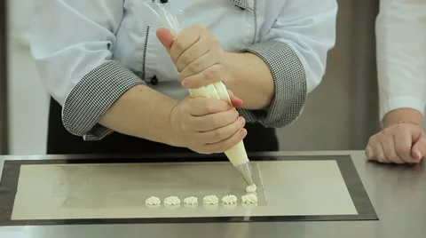 Close up of the confectioner-cook hands squeezes cream and makes parts for cake Stock Footage 50475381