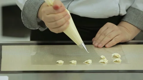 Close up of the confectioner-cook hands squeezes cream and makes parts for cake Stock Footage 50475824