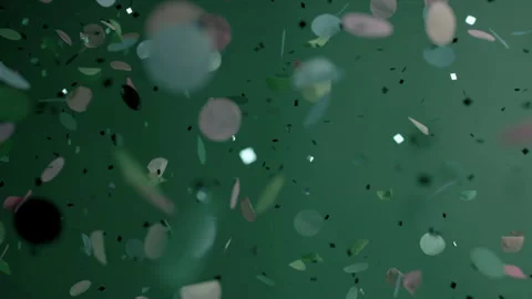 Close up of Confetti and Glitter Falling Against a Green Backdrop Stock Footage 270409738