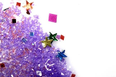 Close up of confetti tinsel glitter and shining stars on white background Stock Photos