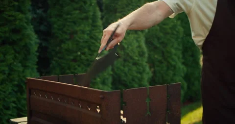 Close-up of a confident guy in a white T-shirt and brown apron swinging a fire Stock Footage 278714103