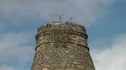 Close up conical bottle pottery kiln moving clouds weeds blue sky Stock Footage 47236382