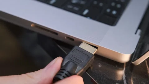 Close-up of connecting an HDMI cable to a laptop, highlighting external monitor Stock Footage 333649429