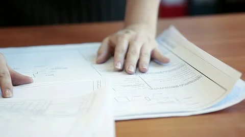 Close up of construction blueprints on table with female hands Stock Footage
