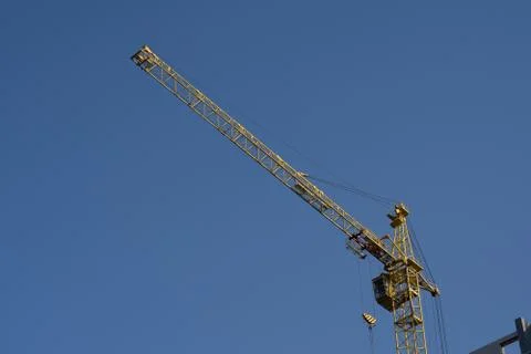 Close up of construction crane on background of blue sky. Stock Photos