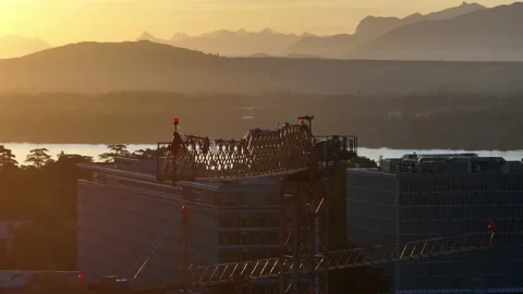 Close up of a construction crane with the sunset or sunrise in the background Stock Footage 233877209