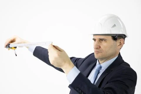 Close up construction engineer in safety helmet looking on measuring tape Stock Photos