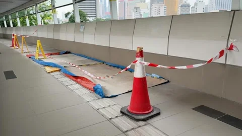 Close up of Construction Materials and Cone Blocking Skywalk Corridor with City 스톡 동영상 343475711