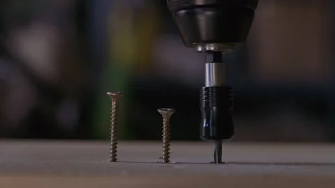 Close-up construction scene showing a power screwdriver fastening three screws Stock Footage 346901396