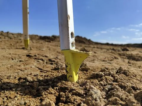 Close-up of construction stakes in sandy soil under clear blue sky Stock Photos
