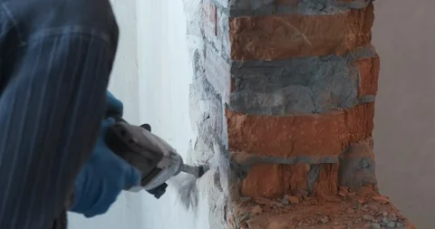 Close-up of construction work with jackhammer, builder chop off layer of plaster Stock Footage 123951647