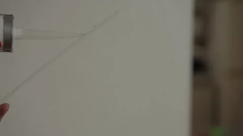 Close-up of construction worker applying liquid nails using silicone gun on Stock Footage 307557846