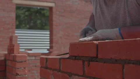 Close-up of a construction worker gloved hands, laying red bricks Stock-Footage 336739074