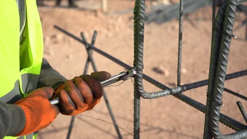Close-Up of Construction Worker Hands Tying Steel Rebar Framework with Pliers Vídeos de archivo 334878018