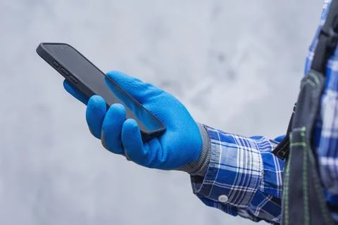 Close-up of a construction worker handyman in protective gloves and workwea.. Foto stock