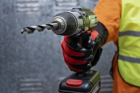 Close up of construction worker holding cordless power drill wearing protec.. Stock Photos