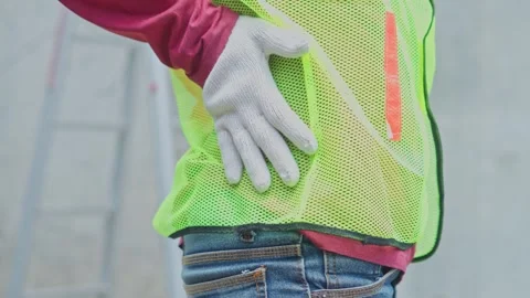 Close-up of construction worker holding lower back in pain suffering from Stock Footage 337122185