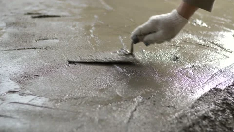 Close-up of a construction worker leveling a concrete screed with a trowel. Stock Footage 234647291
