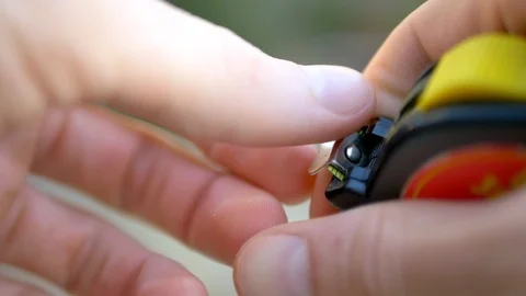 Close up of a construction worker pulling out a yellow tape measure to Stock Footage 95782328
