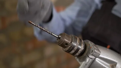 Close-up of a construction worker securing a drill bit in a power drill Stock Footage 330357759