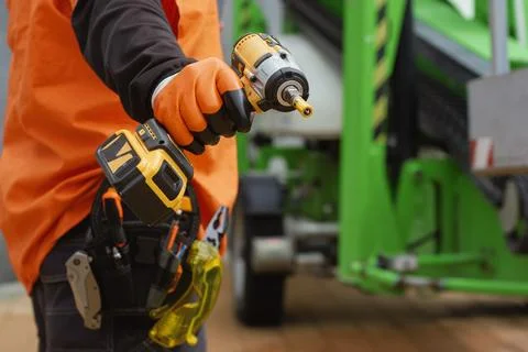 Close-up of a construction worker with a tool belt, wearing protective gloves Stock Photos
