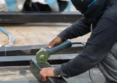 Close-up of a construction worker using an angle grinder to cut a heavy bla.. Stock-Fotos