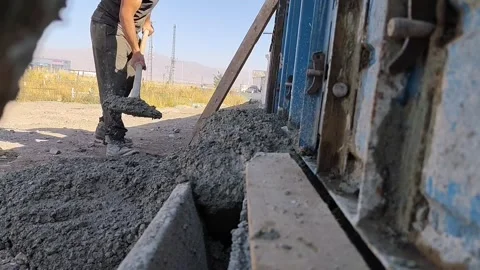 Close-up of a construction worker using a shovel to level and distribute wet Vídeo Stock 333240794