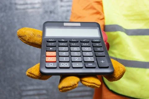 Close-up of a construction worker wearing protective gloves and safety vest.. Stock Photos