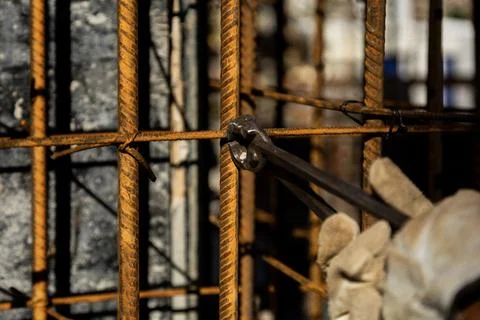 Close-up of a construction worker wearing protective gloves and using pliers  Stock Photos