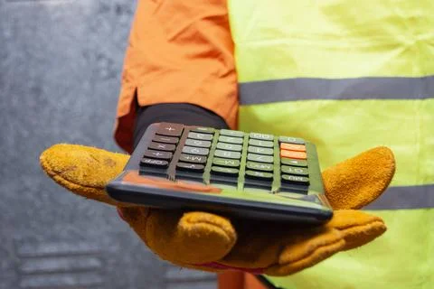 Close-up of a construction worker wearing protective gloves and safety vest.. Stock Photos