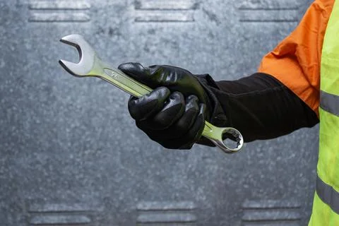 Close-up of a construction worker wearing safety gloves and reflective vest h Stock Photos