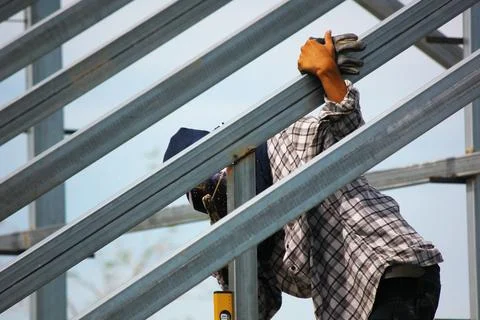 Close up construction worker welding new house roof beam Fotos de archivo