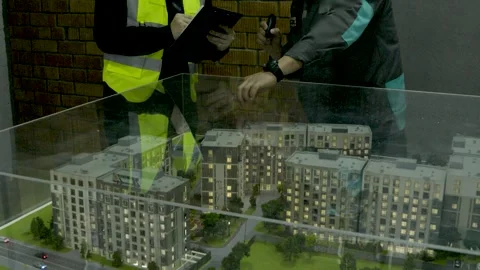 Close-up of construction workers analyzing blueprints on a building site Stock Footage 323167906