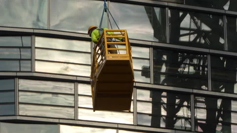 Close up of construction workers in elevated lift, exterior of  glass building Stock Footage 332907479