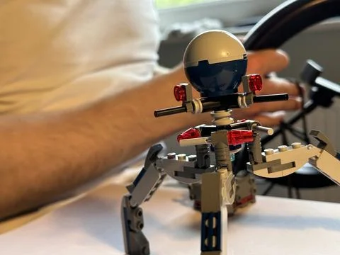 Close up of a constructor toy build from building blocks, unrecognizable man  Stock Photos