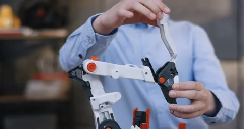 Close up of the constructor toy in hands of the little Caucasian boy in the blue Video stock 135843132