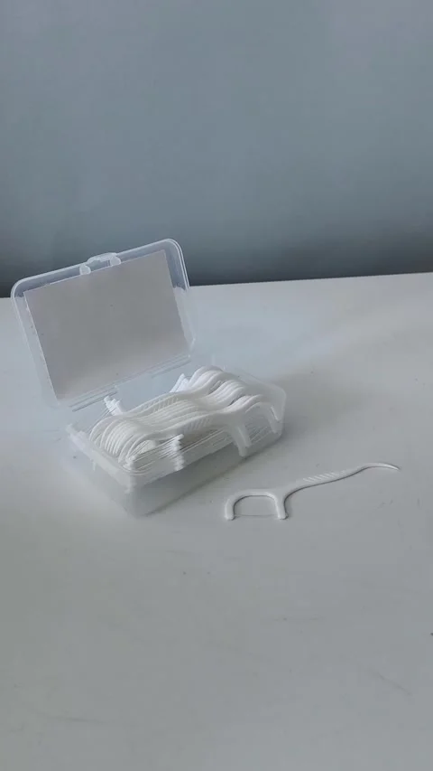 Close-up of a container of dental floss and flossers on a table. Teeth cleaning Vidéo 329969443