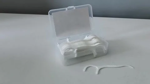 Close-up of a container of dental floss and flossers on a table. Teeth cleaning Vidéo 329969452