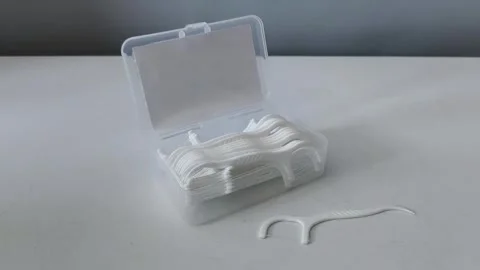 Close-up of a container of dental floss and flossers on a table. Teeth cleaning Stock-Footage 329969459